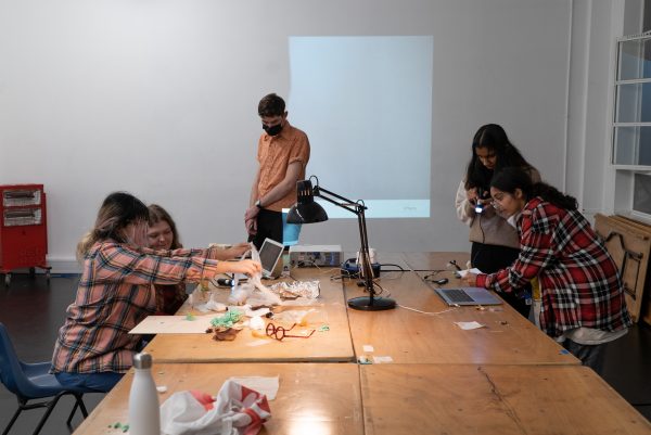 Group of young people around a table looking at random objects