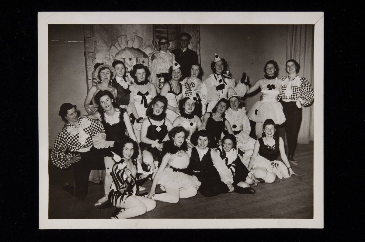 Black and white photo of actors in costume on a stage