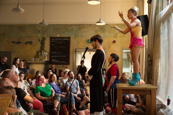a performer on a table in a cafe filled with people