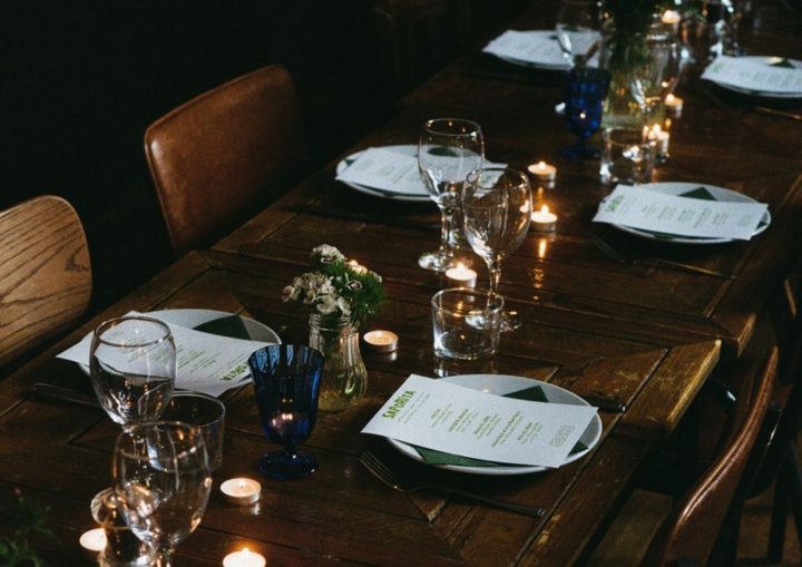 A photo of a dimly-lit, festively dressed dining table with wintry accents 