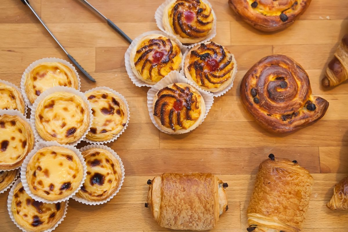 Custard tarts and pastries on a wooden board
