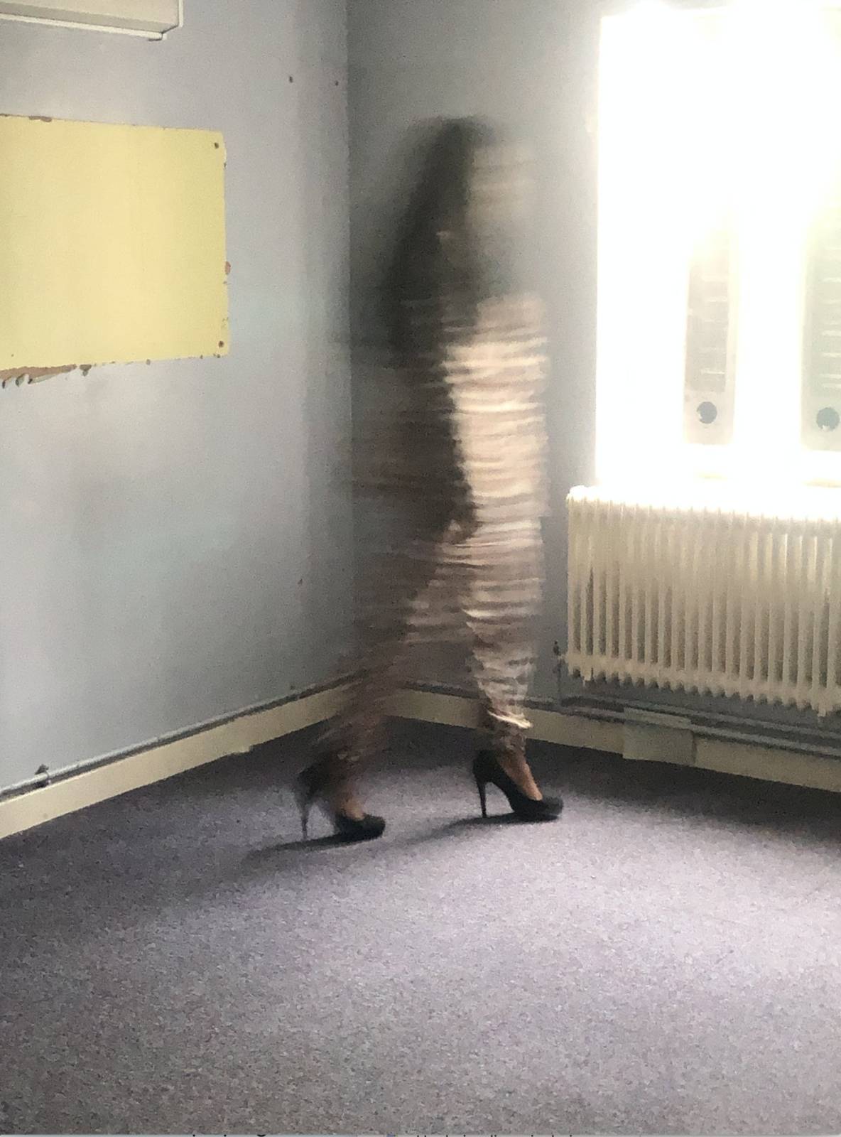 Blurred image of Lady Unchained standing by the window in her old empty prison cell