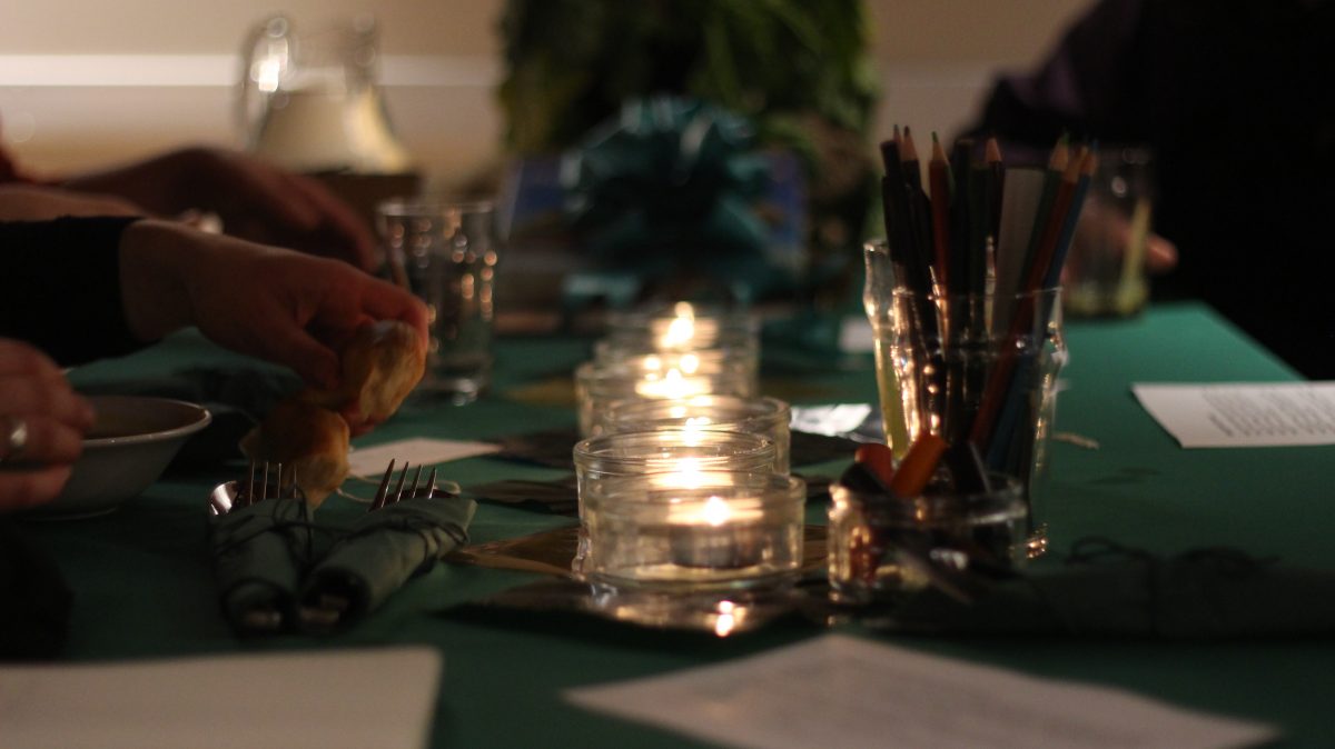 Dinner table with candles, cutlery and pencils in cups