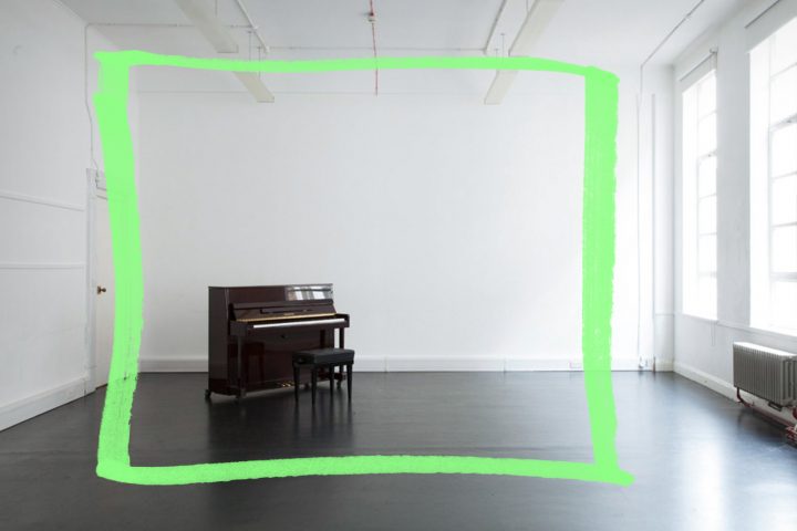 an empty studio with dark wooden floors, white walls, large windows and a piano in the middle