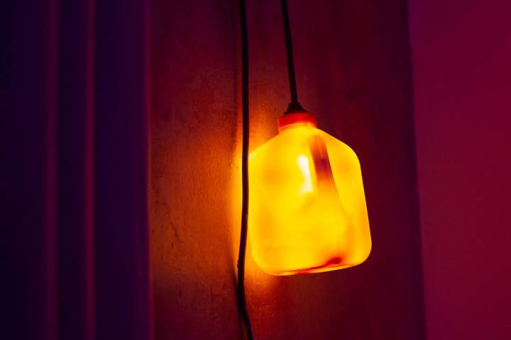 Orange illuminated water canister hanging off a wall