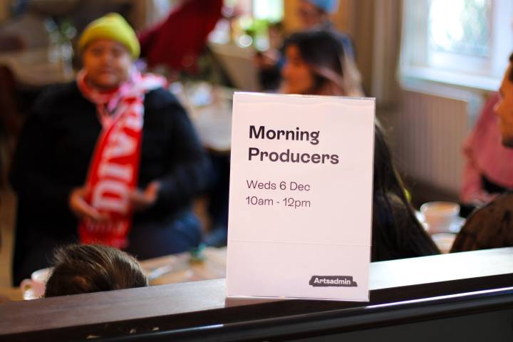 a photo of a sign reading "Morning Producers" in the background, people are gathered in the Artsadmin Canteen